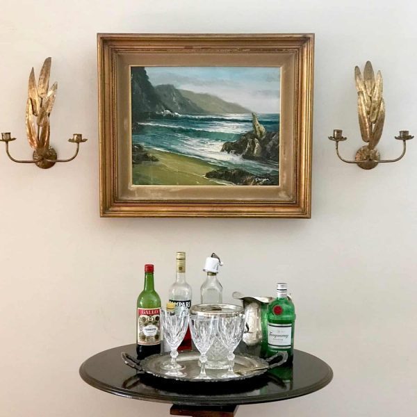 bar table with vintage sconces and oil painting