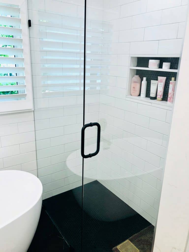 black penny tile in shower and wall niche