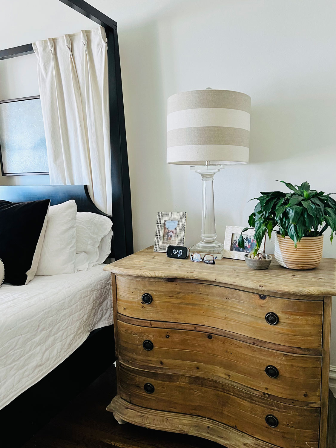 bedside chest with striped lamp shade and clock