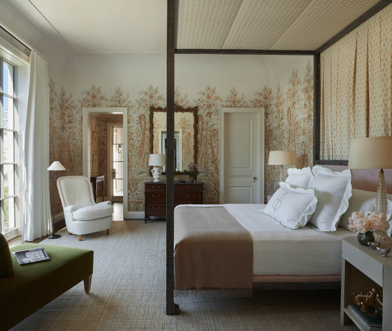 wallpapered room with four poster bed